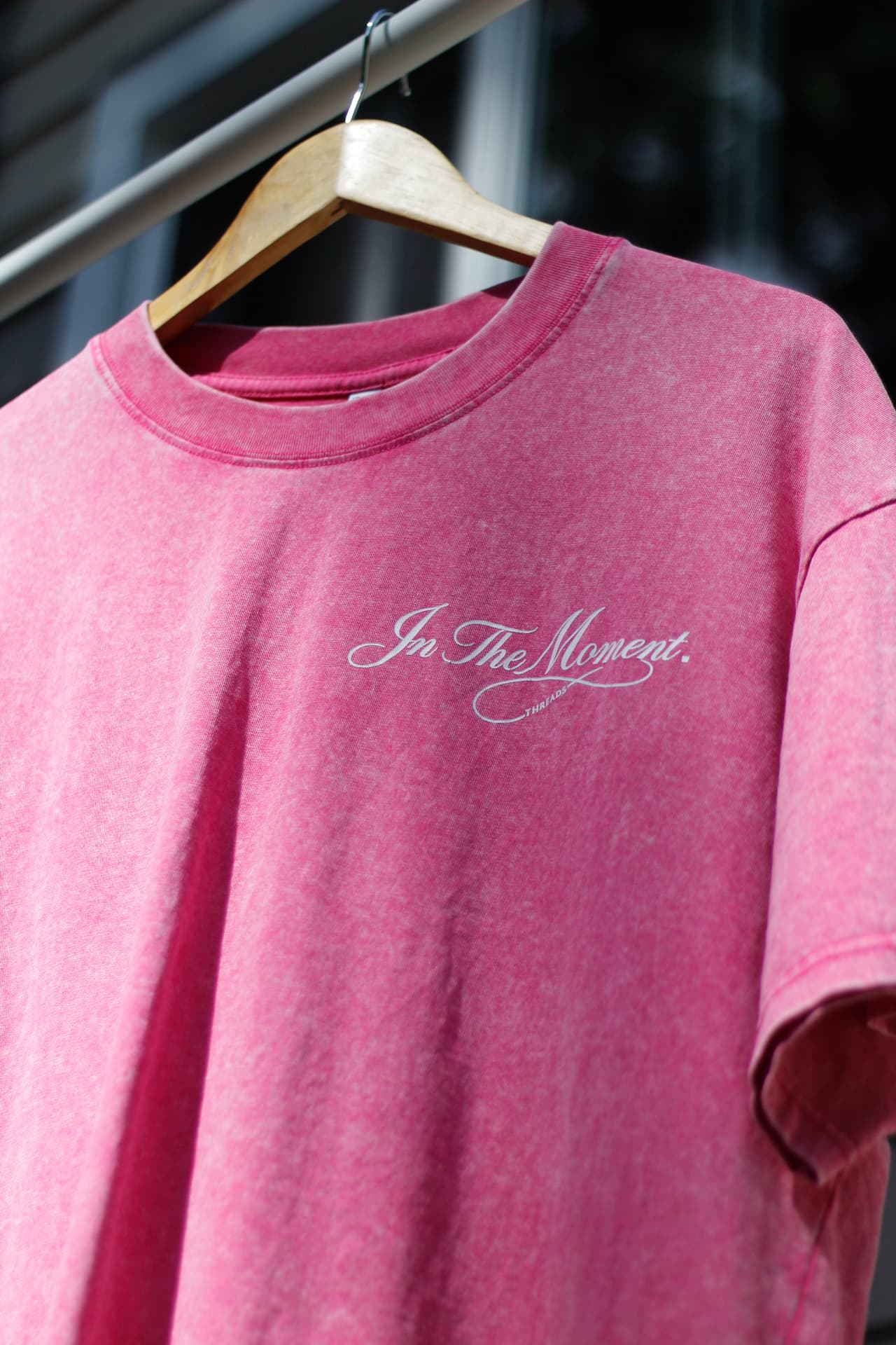 Vintage-wash pink In The Moment tee on a wooden hanger